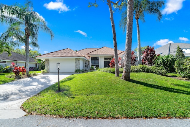 view of front of home with a garage, concrete driveway, a tiled roof, a front yard, and stucco siding