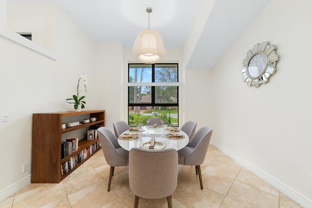 tiled dining space featuring baseboards