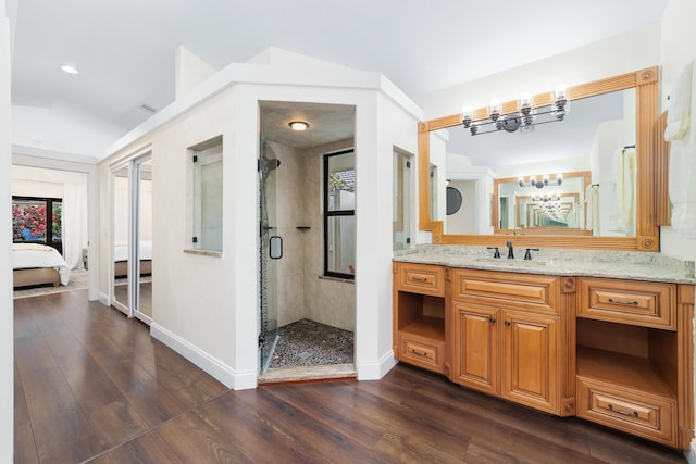 full bathroom featuring a stall shower, baseboards, connected bathroom, wood finished floors, and an inviting chandelier