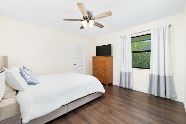 bedroom featuring ceiling fan, a closet, wood finished floors, and baseboards