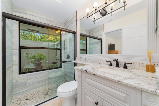 full bathroom with a stall shower, vanity, and toilet