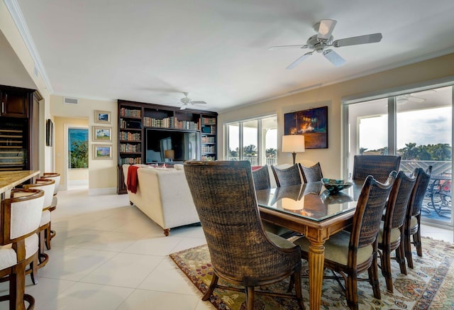 dining space featuring light tile patterned floors, visible vents, a ceiling fan, baseboards, and ornamental molding