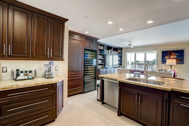 kitchen featuring decorative backsplash, dishwasher, light stone counters, open floor plan, and a sink