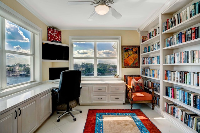 home office with light tile patterned floors, ceiling fan, built in desk, and crown molding