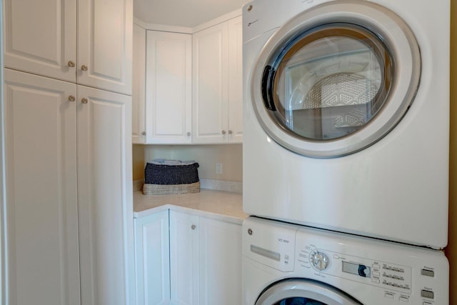 laundry room with cabinet space and stacked washer / dryer