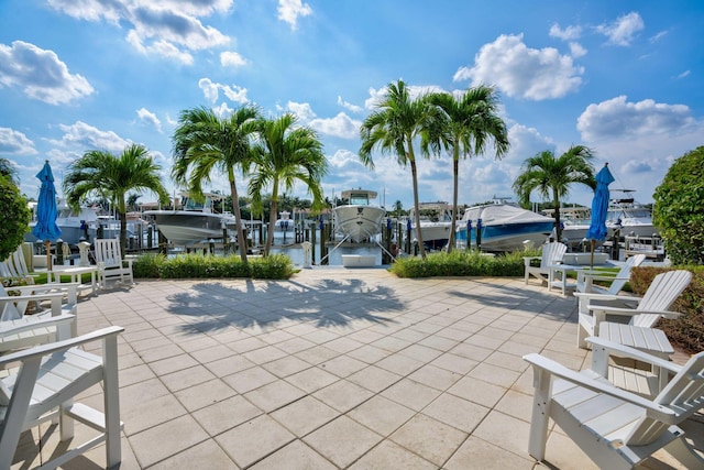 view of property's community with a dock, boat lift, and a patio