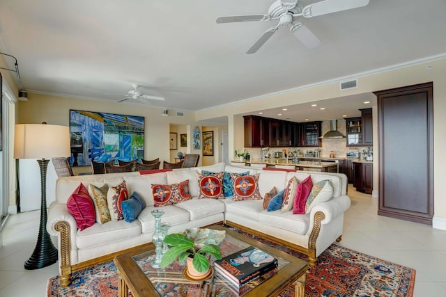 living room featuring light tile patterned floors, a ceiling fan, visible vents, and crown molding