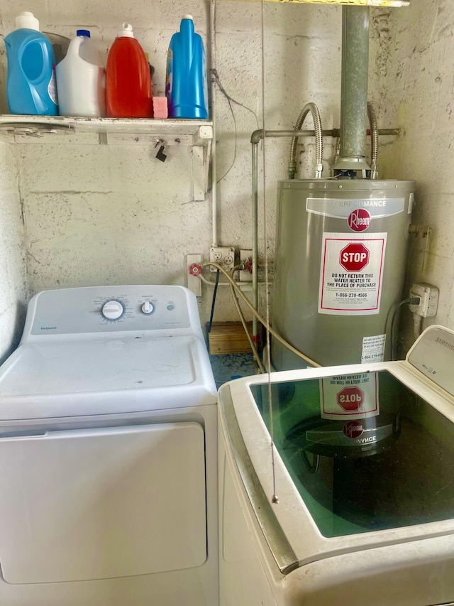 washroom with water heater, laundry area, and washer / clothes dryer