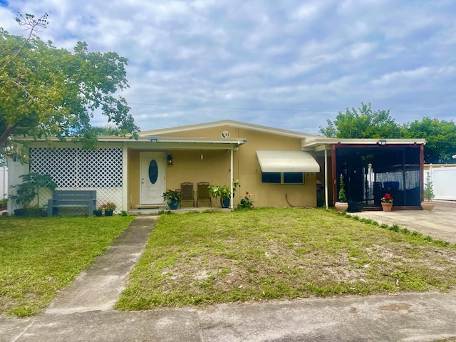 view of front facade with a front yard and stucco siding