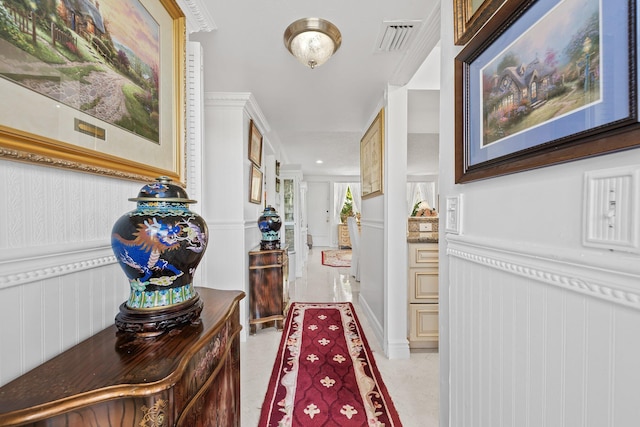 hall featuring a wainscoted wall and visible vents