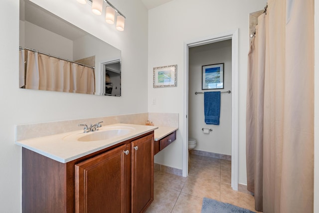 bathroom with toilet, tile patterned flooring, baseboards, and vanity