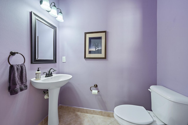 bathroom with toilet, baseboards, a sink, and tile patterned floors