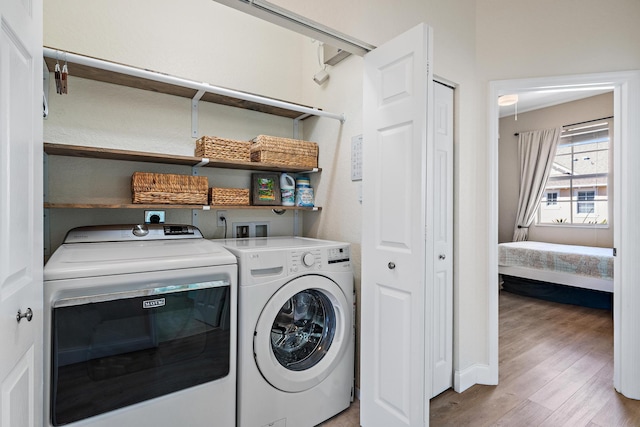 clothes washing area with laundry area, independent washer and dryer, and wood finished floors