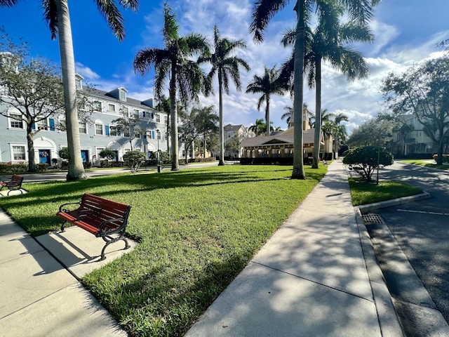 view of property's community with a residential view and a lawn