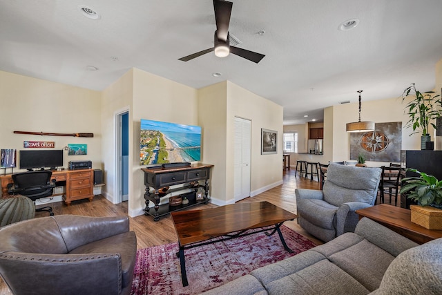 living area with a ceiling fan, recessed lighting, baseboards, and wood finished floors