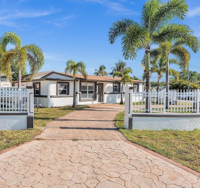 ranch-style house with a fenced front yard and stucco siding