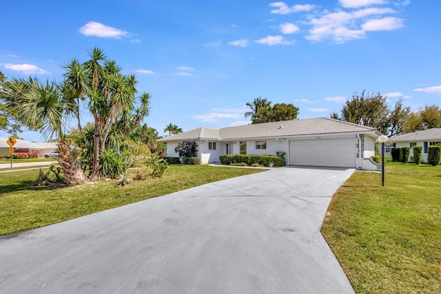 single story home featuring a front lawn, concrete driveway, and an attached garage