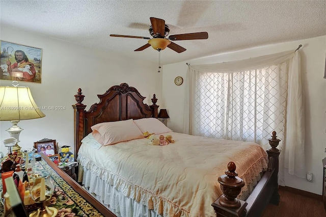 bedroom featuring a ceiling fan, dark wood finished floors, and a textured ceiling