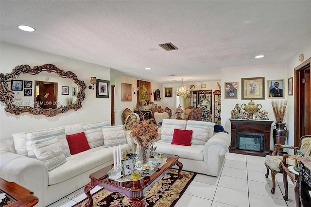 living room featuring recessed lighting, visible vents, a glass covered fireplace, light tile patterned flooring, and a textured ceiling