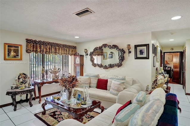 living room with light tile patterned floors, baseboards, visible vents, a textured ceiling, and recessed lighting