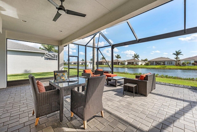 view of patio / terrace with outdoor dining area, a water view, ceiling fan, a lanai, and an outdoor living space