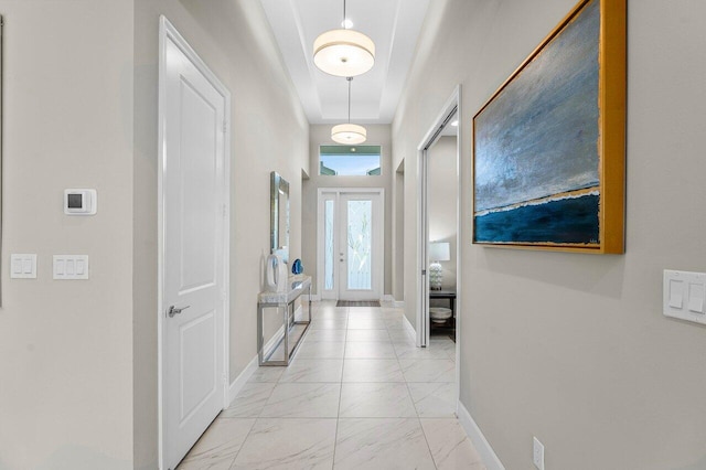 corridor with marble finish floor and baseboards