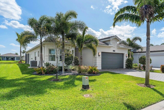 ranch-style house with cooling unit, a garage, decorative driveway, stucco siding, and a front yard