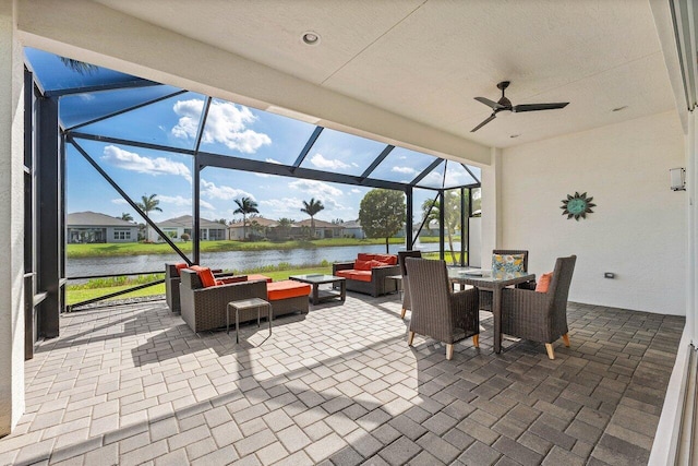 view of patio with a ceiling fan, a water view, a lanai, an outdoor living space, and outdoor dining space