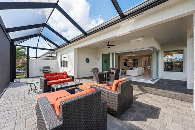 view of patio / terrace featuring a lanai, outdoor dining area, an outdoor living space, and a ceiling fan