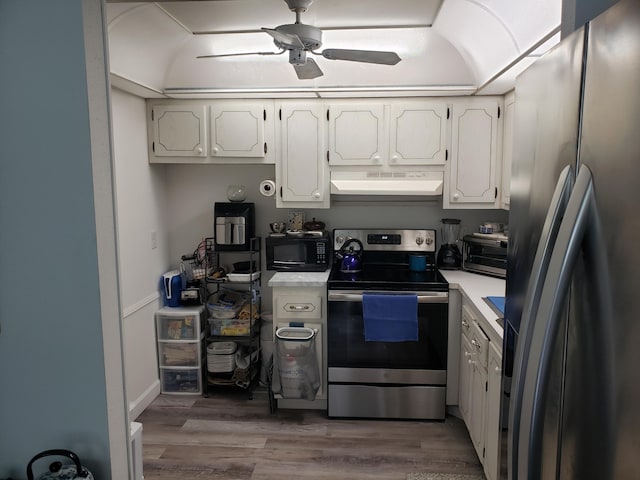 kitchen featuring white cabinets, a ceiling fan, appliances with stainless steel finishes, wood finished floors, and ventilation hood