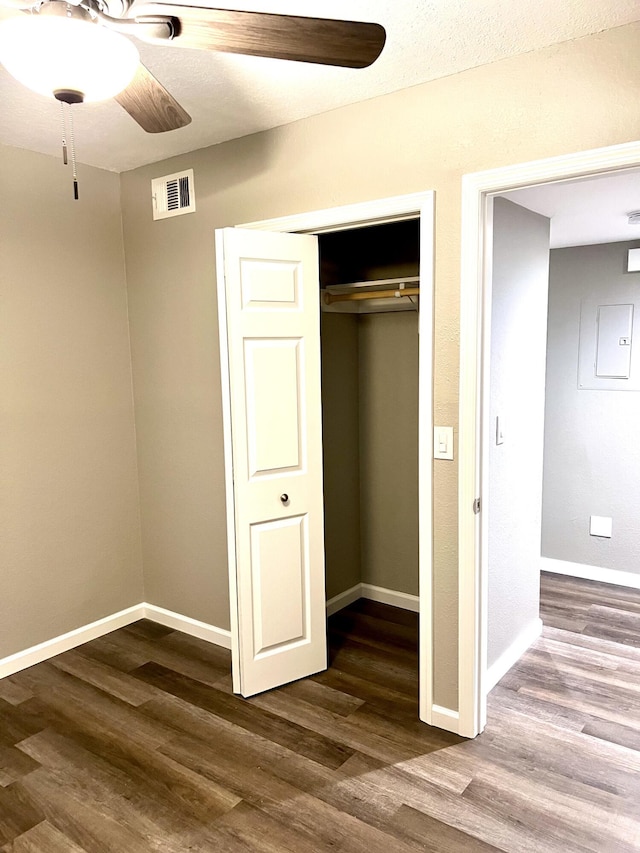 1548 SE Royal Green Cir Unit 105, Port Saint Lucie, FL 34952 - unfurnished bedroom with wood finished floors, baseboards, a closet, electric panel, and ceiling fan