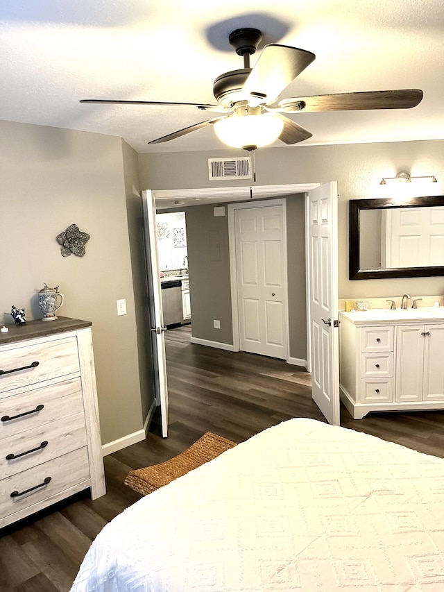 1548 SE Royal Green Cir Unit 105, Port Saint Lucie, FL 34952 - bedroom with dark wood-style floors, baseboards, ensuite bathroom, a ceiling fan, and a sink