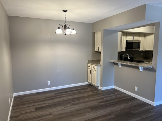 1548 SE Royal Green Cir Unit 105, Port Saint Lucie, FL 34952 - kitchen featuring stainless steel microwave, dark wood finished floors, range with electric stovetop, stone countertops, and white cabinets