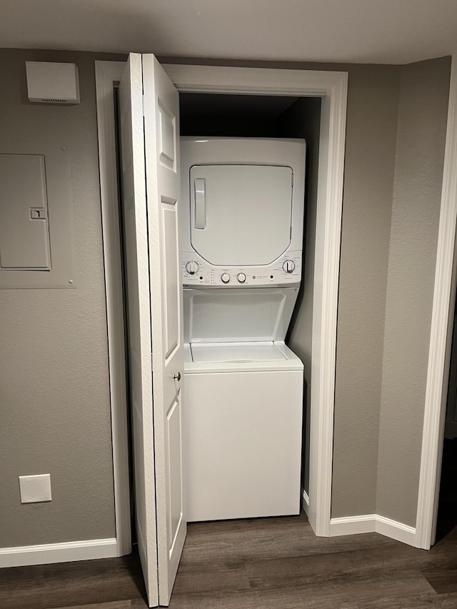 1548 SE Royal Green Cir Unit 105, Port Saint Lucie, FL 34952 - laundry area with stacked washing machine and dryer, dark wood-style flooring, and baseboards