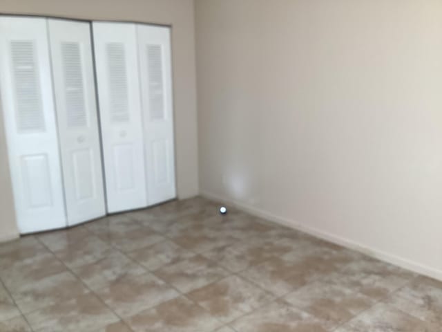 unfurnished bedroom with baseboards, a closet, and tile patterned floors