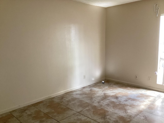 unfurnished room featuring baseboards