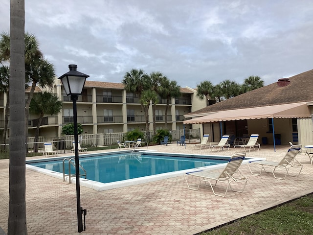 community pool featuring a patio and fence