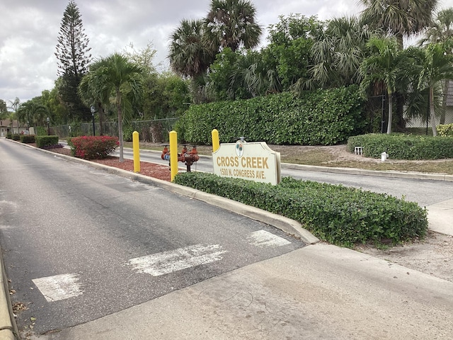 view of street with curbs and a gated entry