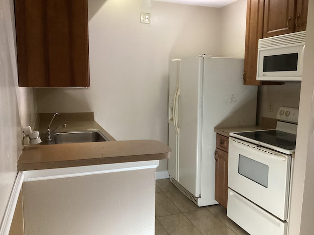 kitchen with white appliances, a sink, and light tile patterned floors