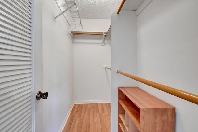 walk in closet with wood finished floors