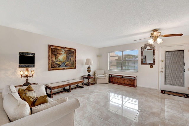 living area with a textured ceiling, ceiling fan, and baseboards