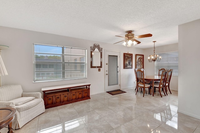 foyer featuring baseboards, a textured ceiling, and ceiling fan with notable chandelier