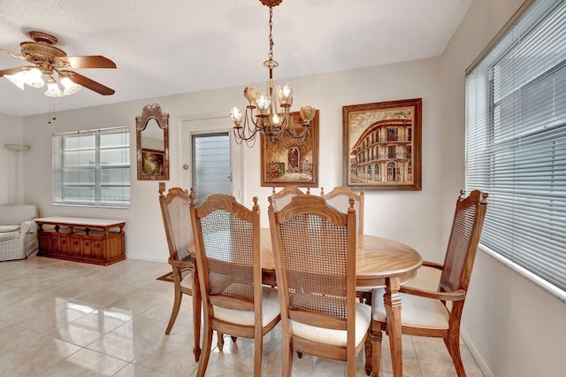 dining room featuring light tile patterned flooring, a textured ceiling, baseboards, and ceiling fan with notable chandelier