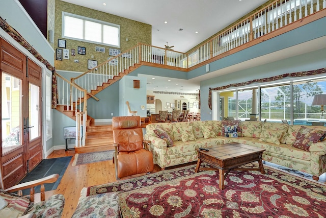 living room with baseboards, a high ceiling, stairway, and wood finished floors