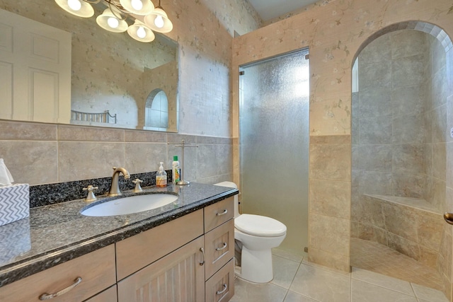 full bath with a walk in shower, tile patterned flooring, toilet, vanity, and tile walls