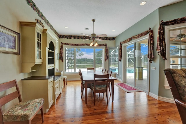 dining space featuring baseboards, ceiling fan, and light wood finished floors