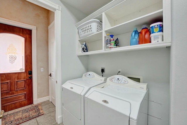 laundry area featuring laundry area, washing machine and clothes dryer, and light tile patterned floors