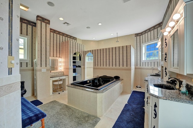 bathroom featuring tile patterned flooring, visible vents, vanity, a bath, and wallpapered walls