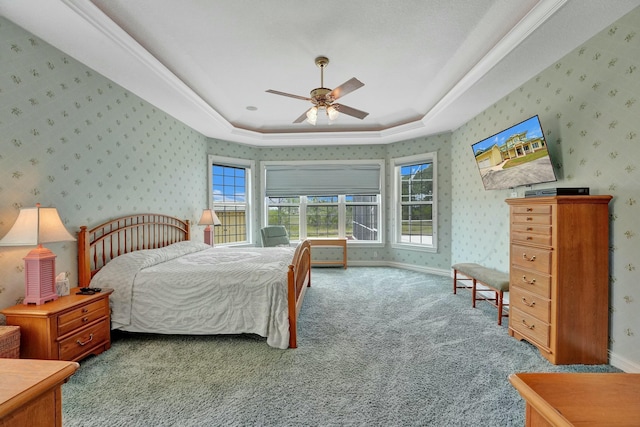 carpeted bedroom featuring wallpapered walls, baseboards, a raised ceiling, and a ceiling fan