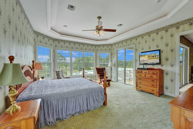 bedroom with access to exterior, a raised ceiling, visible vents, and wallpapered walls